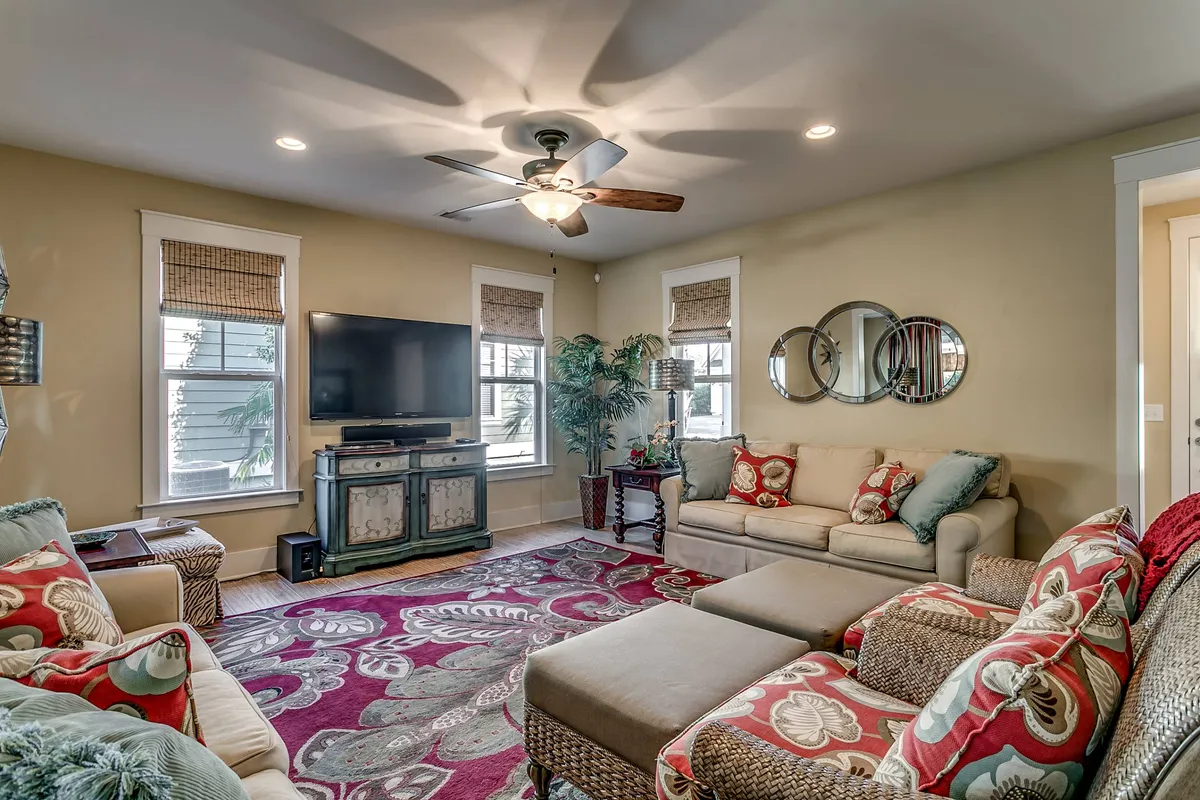 A welcoming living area featuring comfortable seating, a large TV, decorative rugs, and houseplants. The environment is ideal for groups to gather, watch movies, socialize, or simply unwind after a day of adventure.