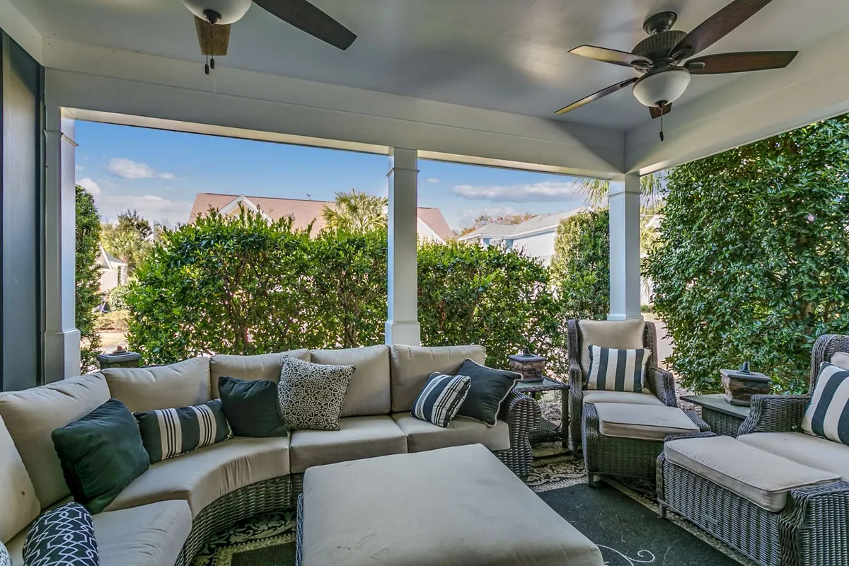 This image showcases a comfortable sectional sofa positioned with a view of outdoor greenery, suggesting a seamless transition from indoor comfort to the inviting outdoor space. Decorative cushions and cozy seating emphasize relaxation and sociable moments, while the visible greenery hints at an adjacent patio area just outside.