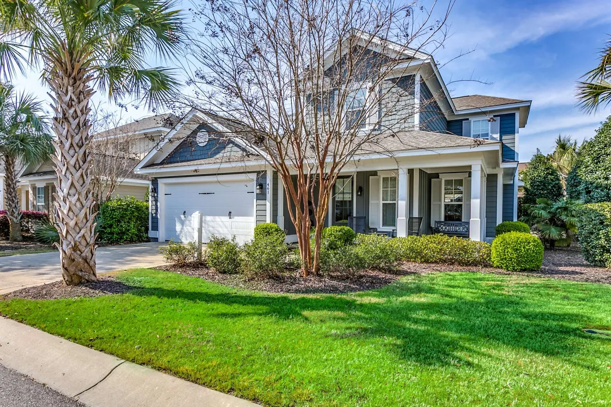 Featuring a charming front porch surrounded by lush greenery, palm trees, and colorful bushes, this image evokes the atmosphere of outdoor leisure. The space is set up for morning coffee, barbecues, and enjoying breezy afternoons, aligning with the alfresco, sun-kissed relaxation described in the section.